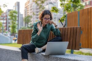 Woman on video call waving at laptop - How to record Zoom calls with RECAP